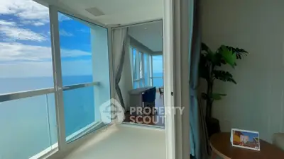 Stunning ocean view from modern high-rise apartment with floor-to-ceiling windows and elegant decor.