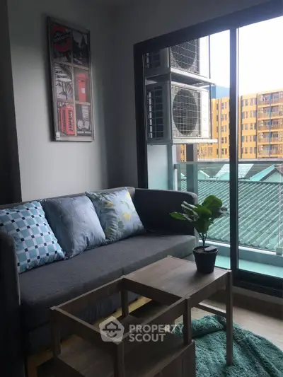 Modern living room with balcony view, stylish decor, and cozy seating area.