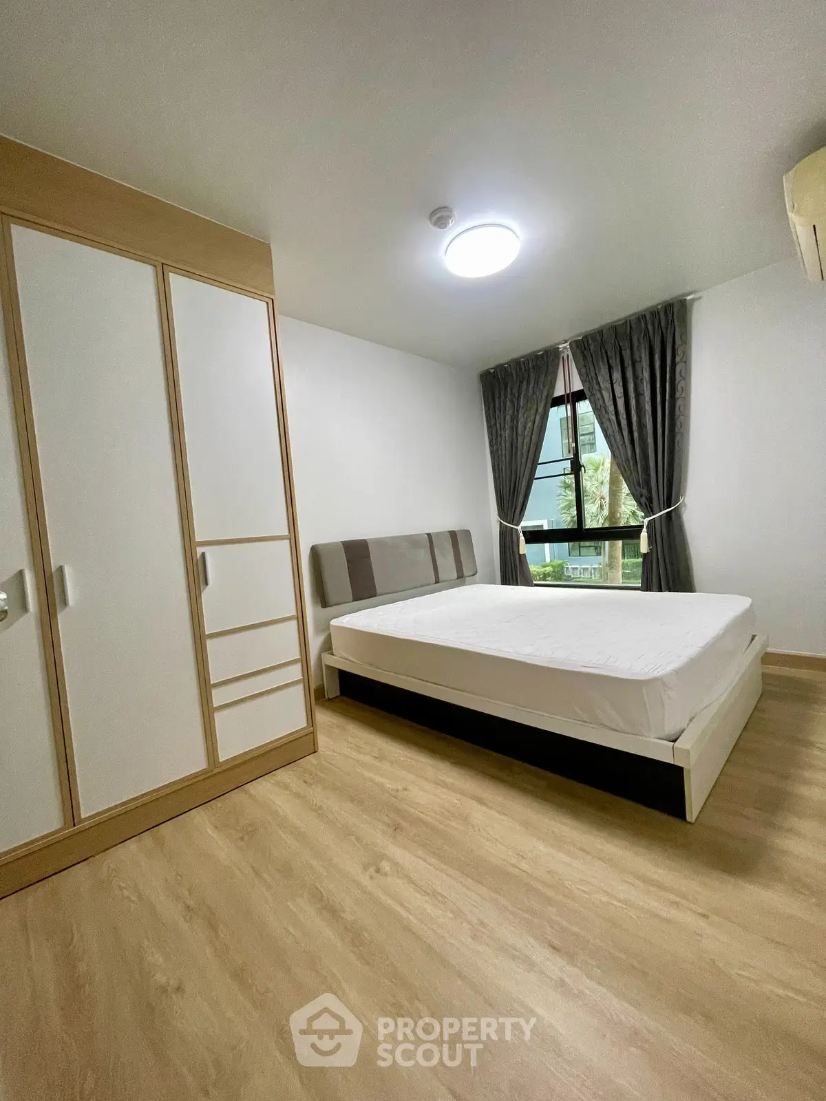 Spacious bedroom with modern wardrobe and large window view