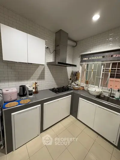 Modern kitchen with sleek cabinets and gas stove, perfect for culinary enthusiasts.