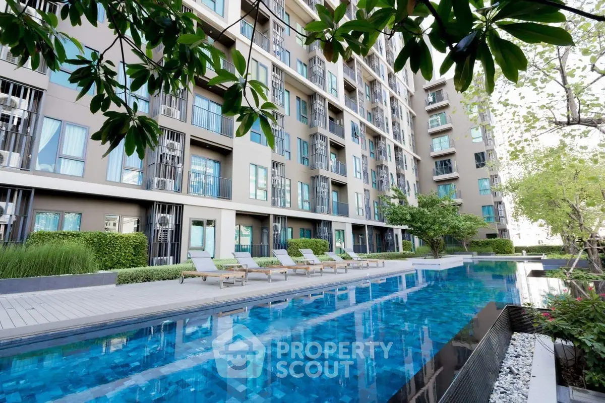 Modern apartment complex with luxurious pool and lush greenery