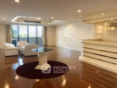 Spacious living room with elegant white furniture and a large window offering a stunning view.