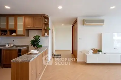 Modern kitchen with wooden cabinets and open layout in a bright apartment.