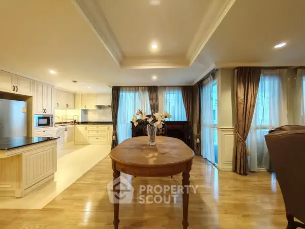 Spacious open-layout kitchen and dining area with elegant wooden flooring and natural light.