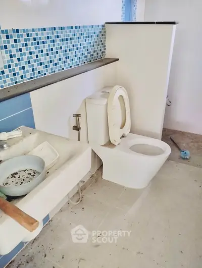 Bathroom with modern fixtures and blue tile accents in real estate property