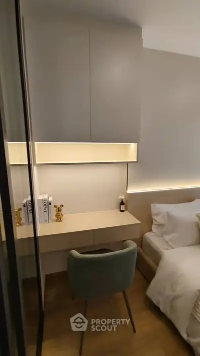 Modern bedroom with sleek design, featuring a cozy bed, stylish chair, and elegant lighting.