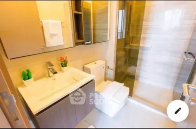 Modern bathroom with sleek fixtures and glass shower enclosure, featuring elegant design and contemporary style.