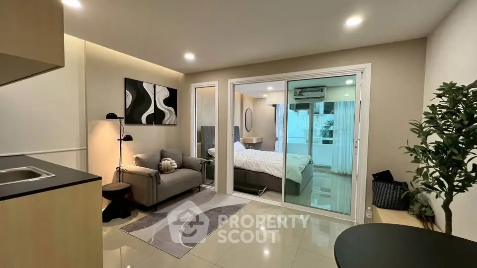 Modern studio apartment with cozy living area and glass partitioned bedroom.