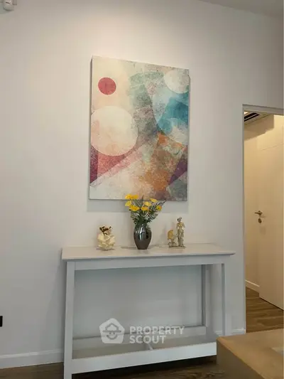 Modern interior with abstract art and elegant console table in a stylish living space.