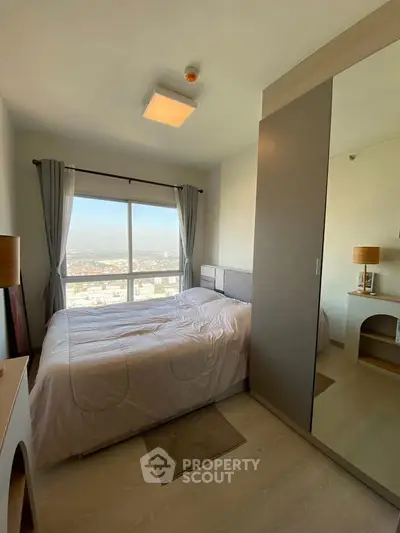 Modern bedroom with large window offering stunning city view, featuring sleek furniture and ample natural light.
