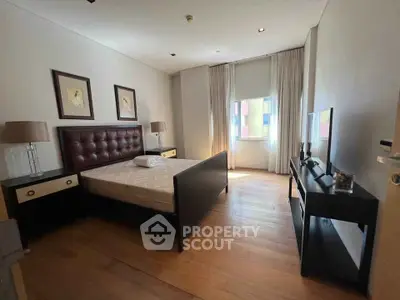 Spacious bedroom with elegant decor and natural light, featuring a comfortable bed and stylish furnishings.