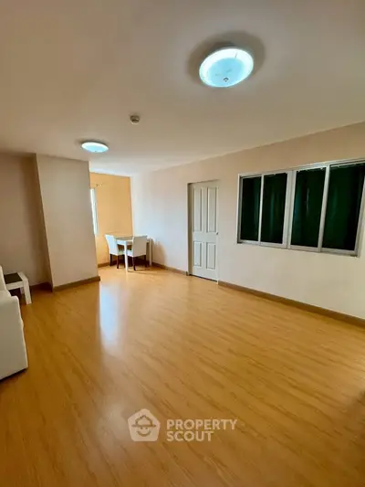 Spacious living room with wooden flooring and natural light