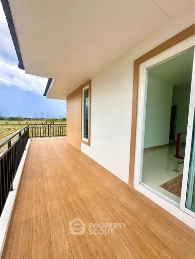 Spacious balcony with wooden flooring and scenic view, perfect for relaxation.