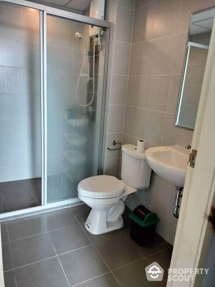 Modern bathroom with glass shower and sleek fixtures in contemporary apartment.