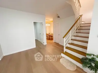 Spacious modern interior with wooden flooring and elegant staircase, perfect for stylish living.