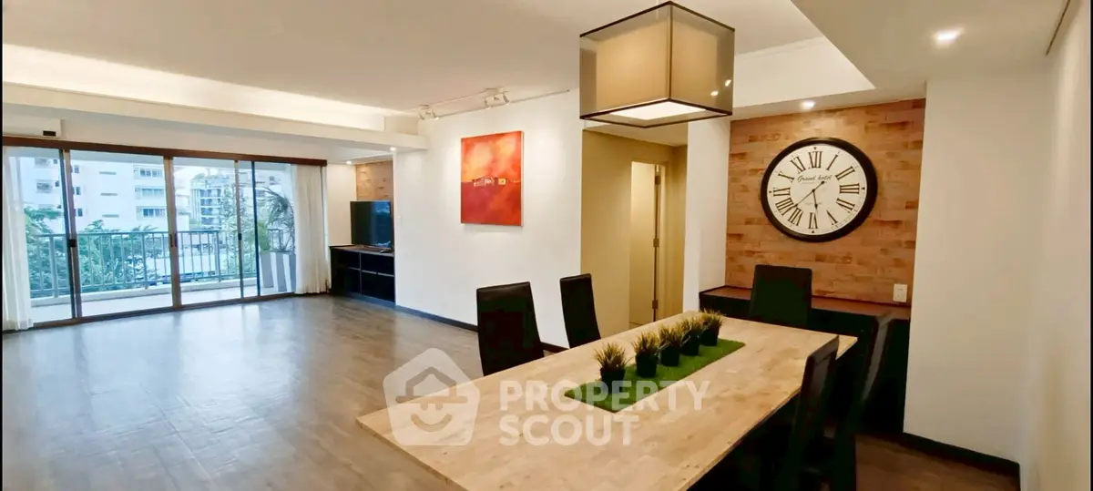 Spacious modern dining area with stylish decor and large windows opening to a balcony.