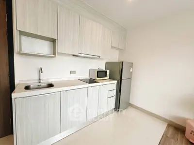 Modern kitchen with sleek cabinetry and stainless steel appliances in a contemporary apartment.