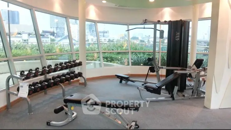 Spacious gym with modern equipment and panoramic city views.