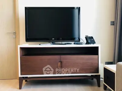 Modern living room with sleek TV stand and flat-screen TV, perfect for entertainment setup.
