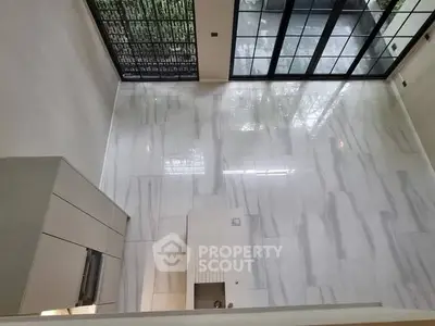 Spacious modern living room with high ceiling and large windows