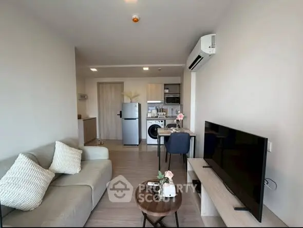 Modern living room with open kitchen, featuring sleek furniture and appliances, ideal for urban living.