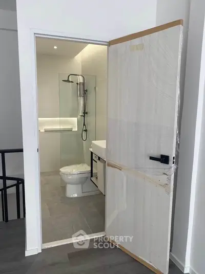 Modern bathroom with glass shower and sleek fixtures in a contemporary home.