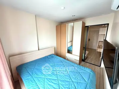 Cozy bedroom with modern furnishings and ample natural light, featuring a large wardrobe and sleek wooden flooring.
