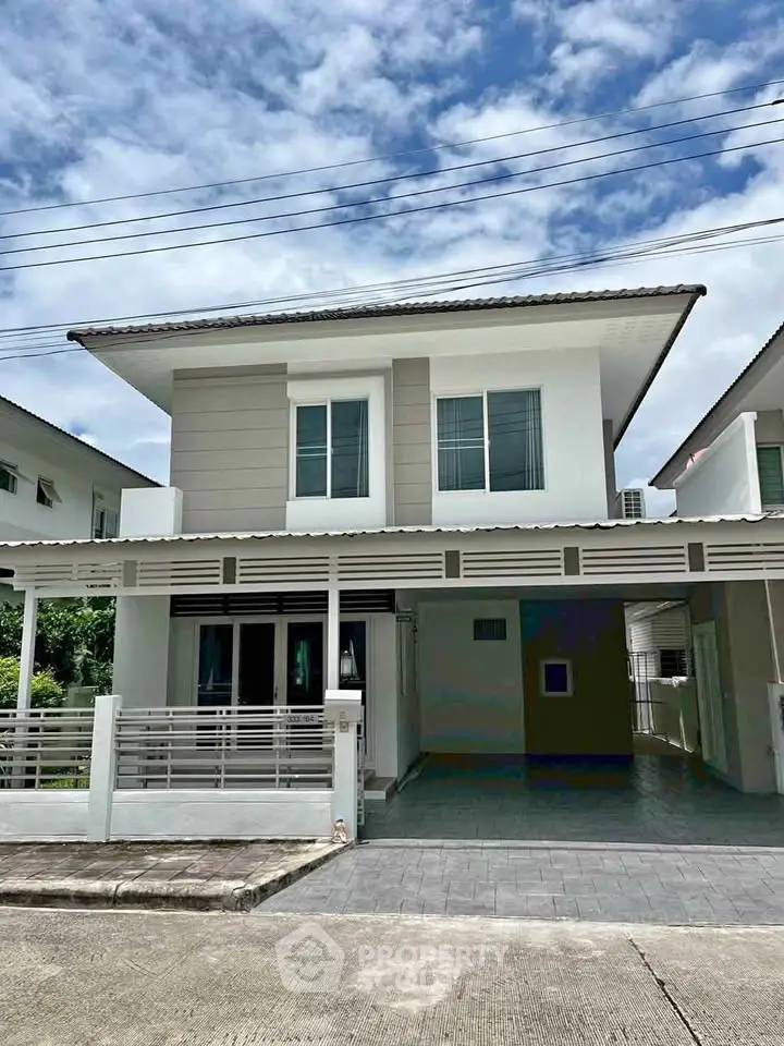 Modern two-story house with a sleek design and spacious driveway in a serene neighborhood.
