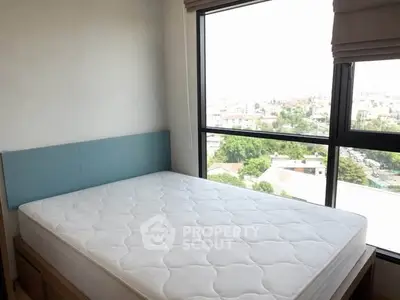 Bright bedroom with large window offering stunning city views, featuring a comfortable bed and modern decor.
