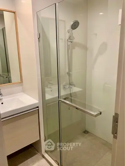 Modern bathroom with glass shower enclosure and sleek vanity unit