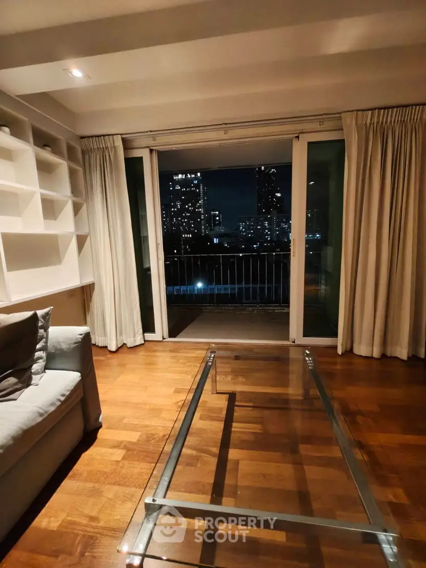 Chic living room with glass coffee table and city skyline view, perfect for urban living.