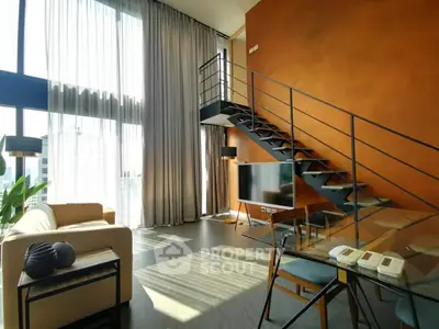 Modern loft-style living room with high ceilings, large windows, and a stylish staircase.