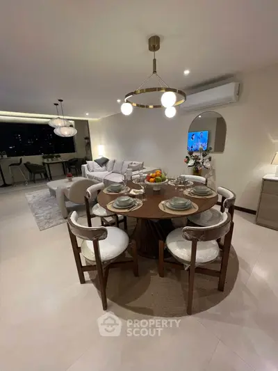 Luxurious open-plan living and dining area with elegant furniture and modern lighting.