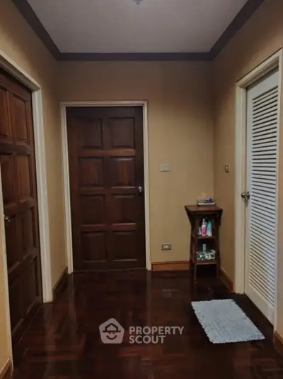 Charming hallway with wooden doors and parquet flooring in cozy home