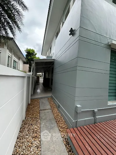 Modern exterior side pathway with sleek design and pebble landscaping