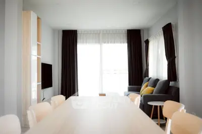Modern living room with sleek furniture and large windows for natural light.