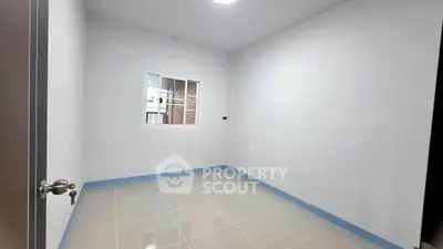 Spacious empty room with tiled floor and window, ideal for customization.