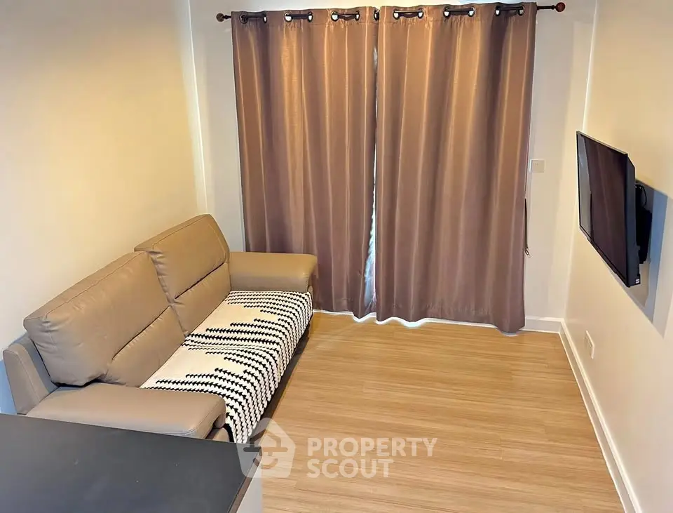 Cozy living room with modern sofa and wall-mounted TV, perfect for relaxation.