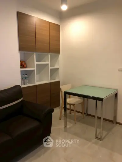 Modern compact living room with sleek furniture and stylish storage cabinets.