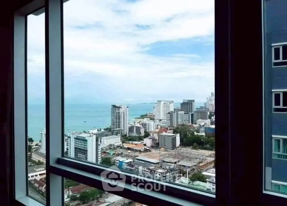 Stunning cityscape and ocean view from high-rise apartment window.
