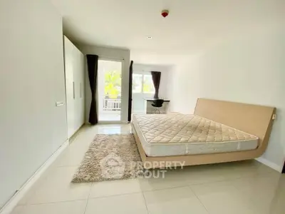Spacious bedroom with modern bed and balcony view in bright apartment