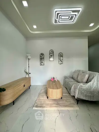 Modern living room with stylish furniture and unique ceiling light fixture, perfect for cozy gatherings.