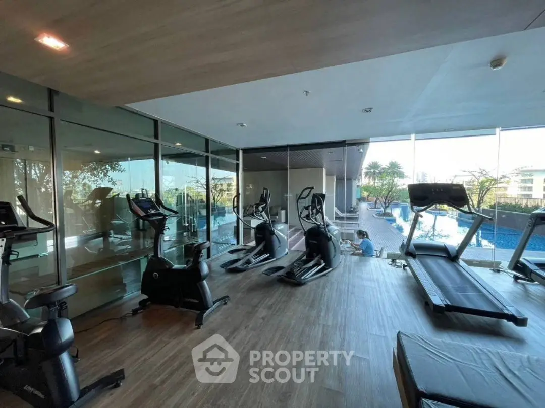 Modern gym with pool view in luxury residential complex