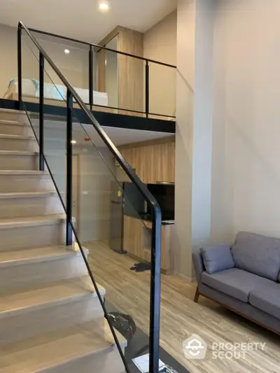 Modern duplex with sleek staircase and cozy living area, featuring wooden accents and minimalist design, perfect for urban living.