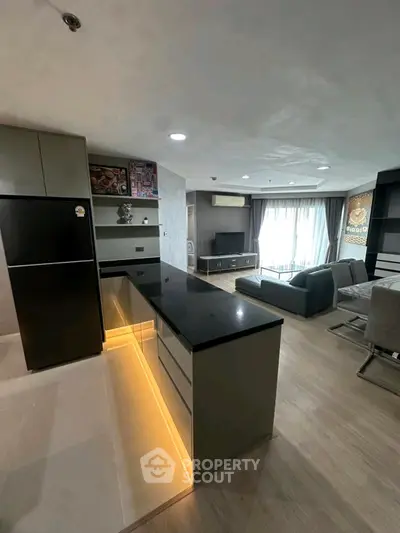 Modern open-layout kitchen and living room with sleek design and ambient lighting.