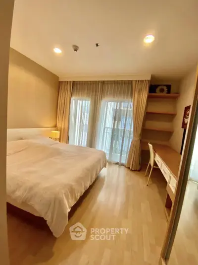 Spacious bedroom with natural light and elegant decor, featuring a cozy bed and work desk.