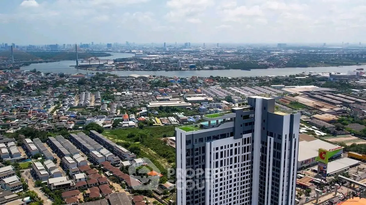 Stunning aerial view of modern high-rise building with cityscape and river in the background.