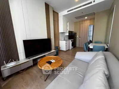 Modern living room with sleek furniture and integrated kitchen appliances in a stylish apartment.
