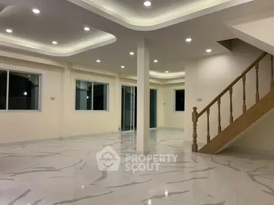 Spacious modern living room with elegant marble flooring and stylish ceiling lights.