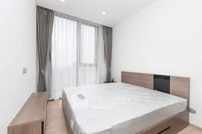 Modern minimalist bedroom with large window and elegant curtains